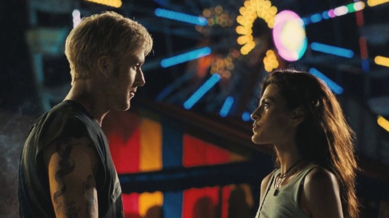 Luke and Romina in front of a lit-up ferris wheel in The Place Beyond The Pines