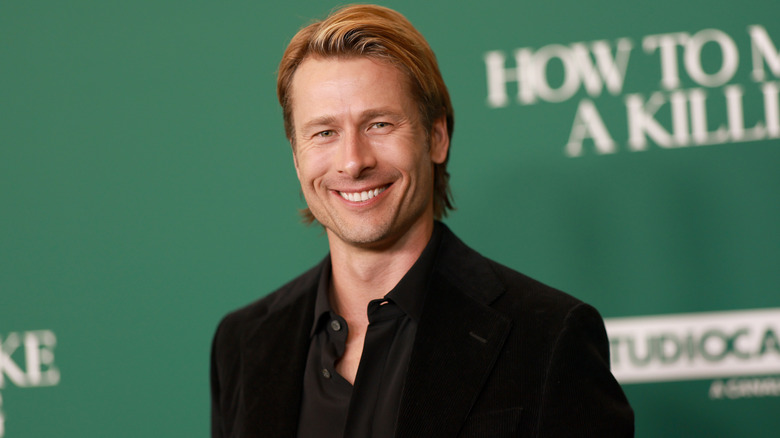 Glen Powell smiling at the Los Angeles Special Screening of A24's "How To Make a Killing"