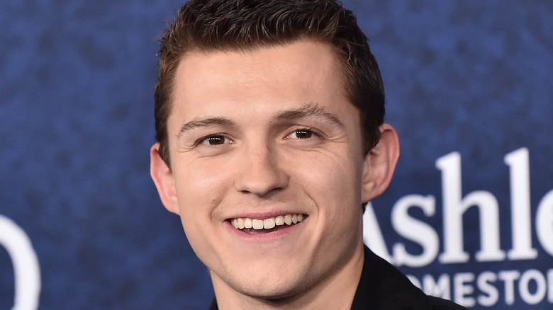 Tom Holland smiling on red carpet