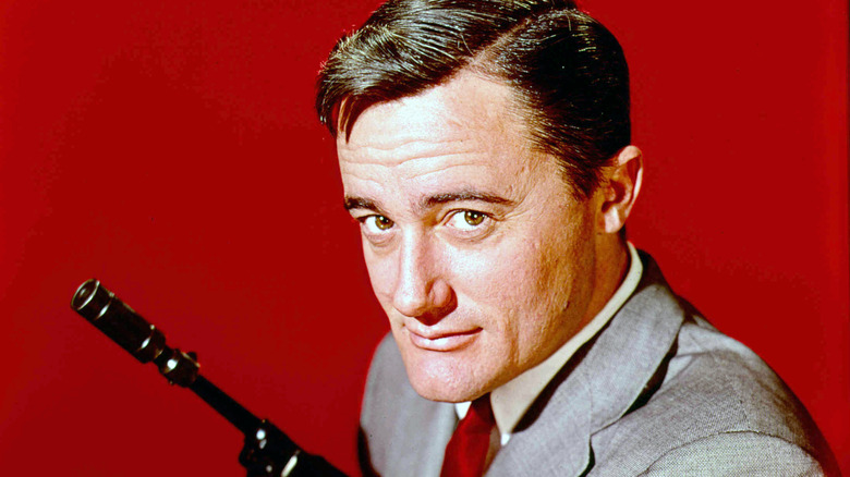 Napoleon Solo holds a gun and smirks