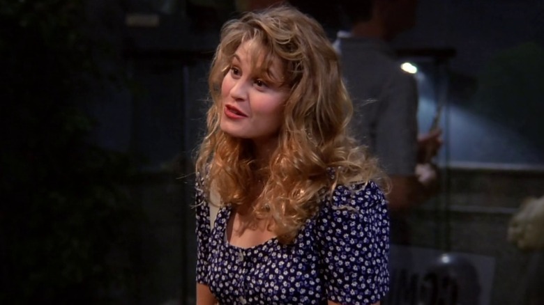 Carol talks to Ross, tilting her head and smiling.