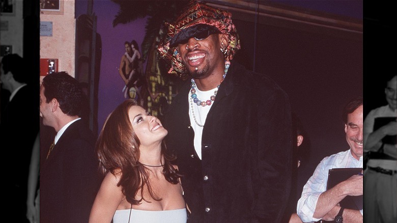 Carmen Electra looks up at Dennis Rodman who is smiling