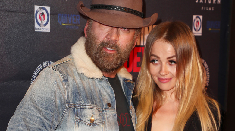 Nicolas Cage in a hat with Erika Koike at the Running with the Devil premiere in 2019