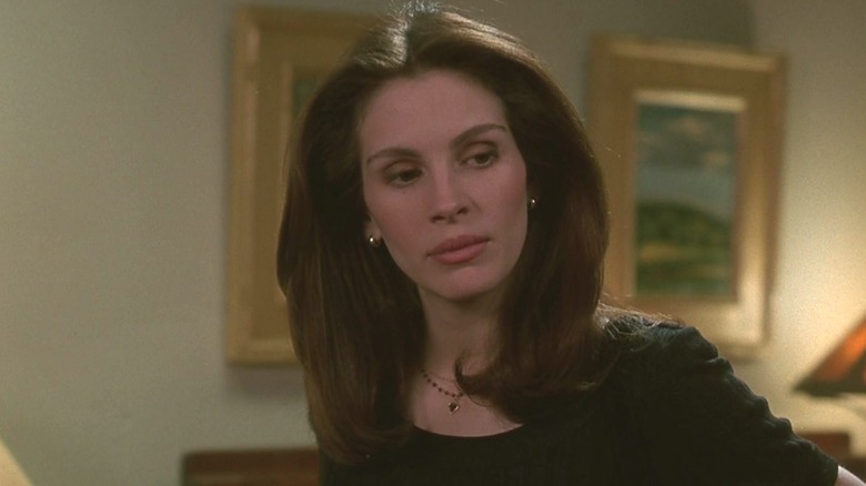 Sabrina Peterson looks down at something in "I Love Trouble" (1994)