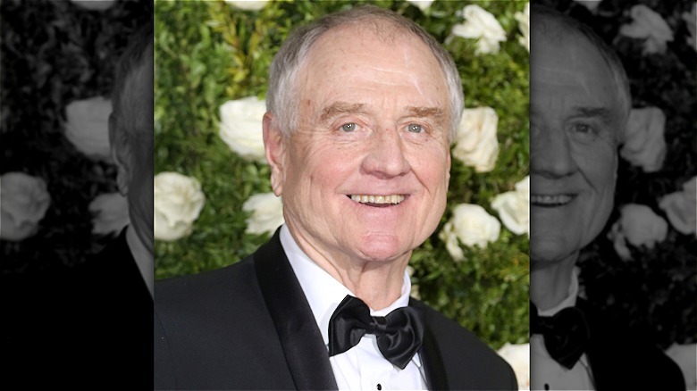 Denis Arndt smiling in front of flower wall