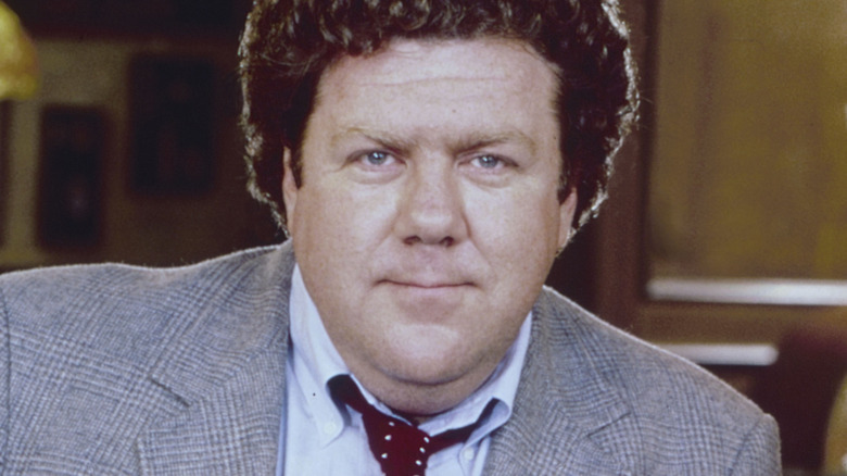 George Wendt in grey suit with red tie