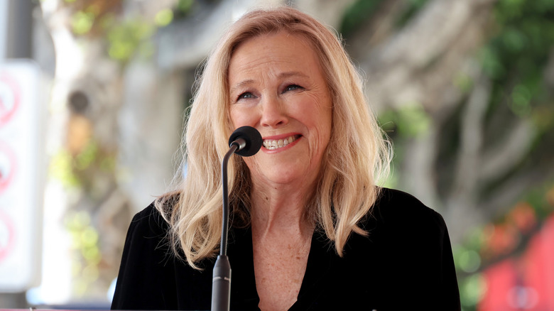 Catherine O'Hara smiling in front of a microphone