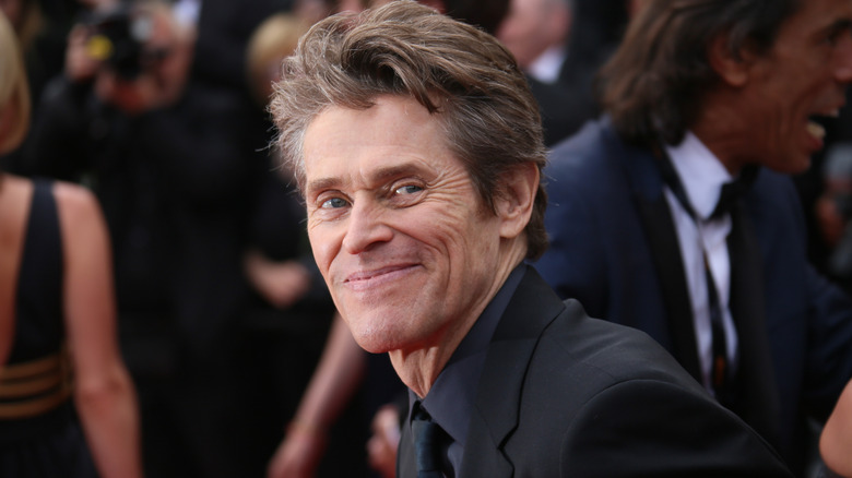 Willem Dafoe smiling for the camera
