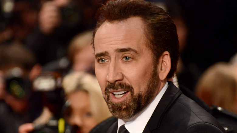 Nicolas Cage smirks at an event