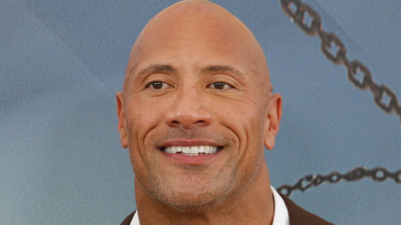 Dwayne Johnson smiling blue background