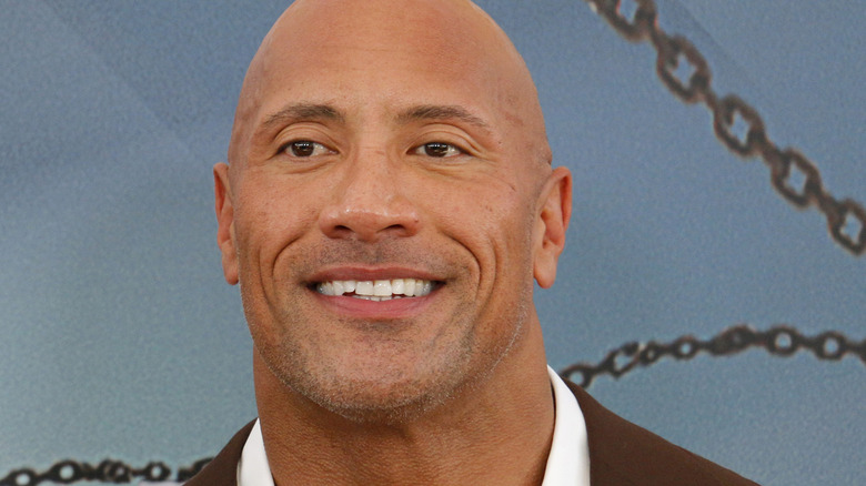 Dwayne Johnson smiling blue background