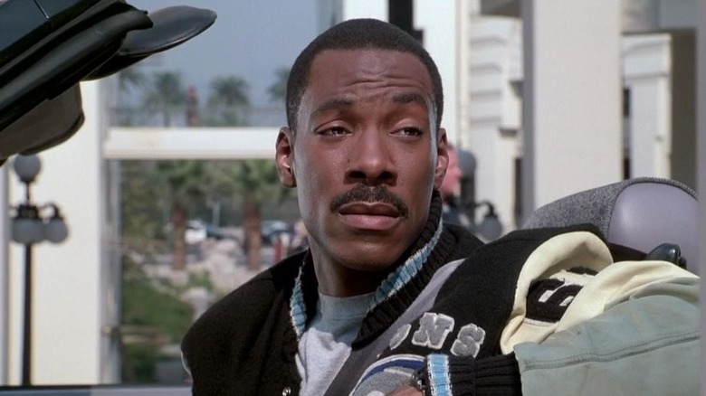 Axel Foley leans back in his convertible