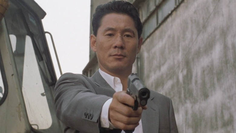 Azuma points gun downward