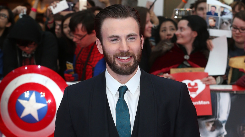 Chris Evans smiling in a suit at the premiere of "Captain America: Civil War"