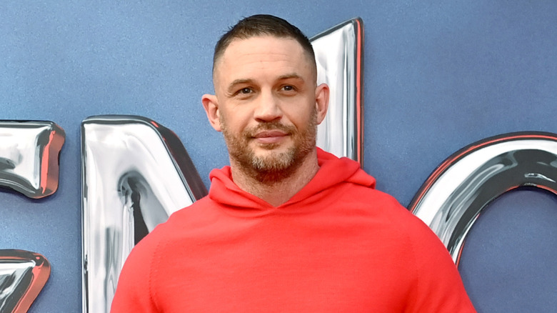 Tom Hardy in a red hoodie at a "Venom" premiere