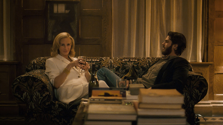 Alma and Hank sit on a couch in "After the Hunt" (2025)