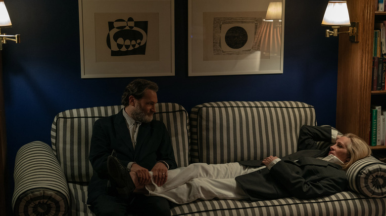 Frederick sits and Alma lies on a couch in "After the Hunt" (2025)