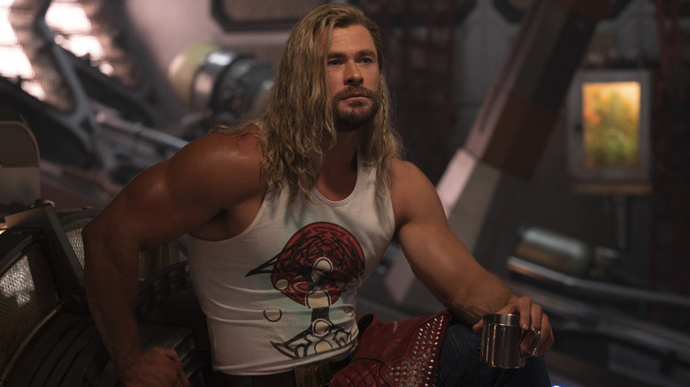 Thor sitting on a ship and holding a cup