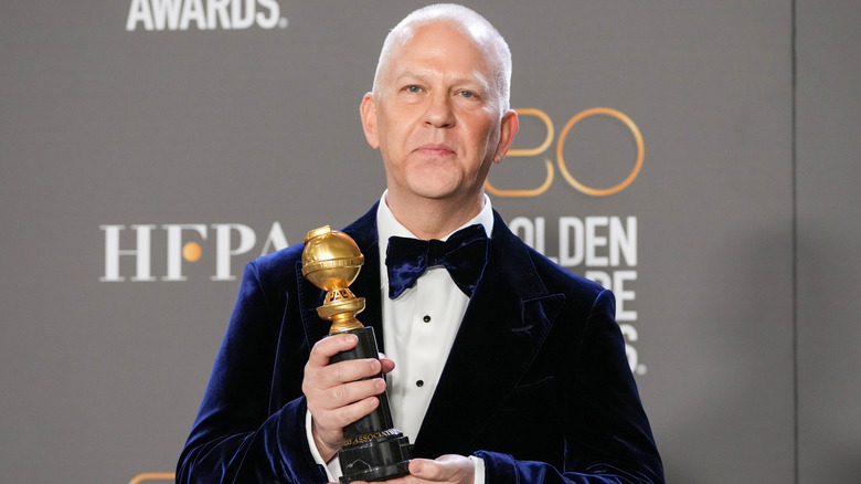 Ryan Murphy posing with a Golden Globe Award