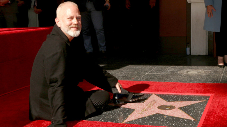 Ryan Murphy sitting by walk of fame star
