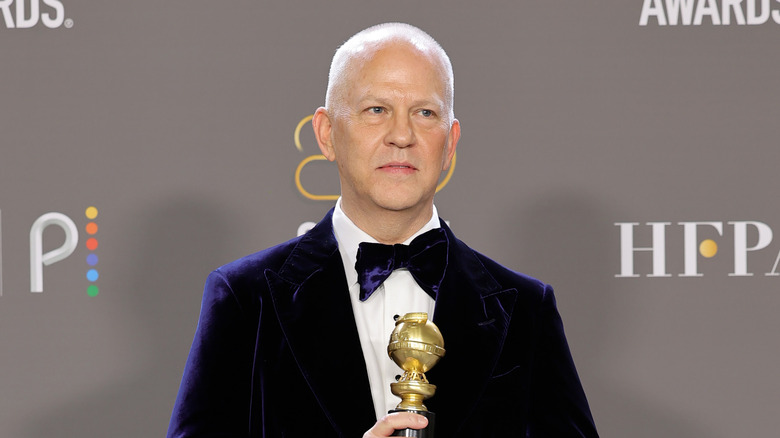 Ryan Murphy holding a Golden Globe