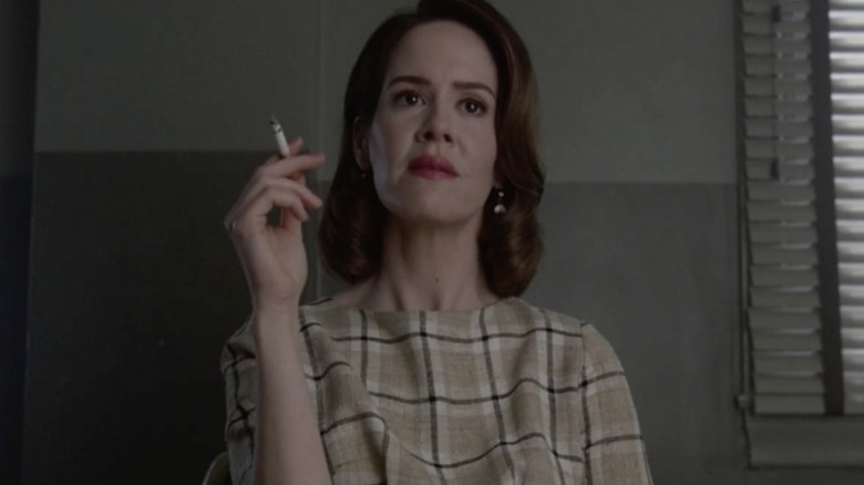 Lana smokes while being interrogated