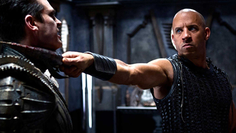 Riddick holding an enemy at blade-point in "Riddick" (2013)
