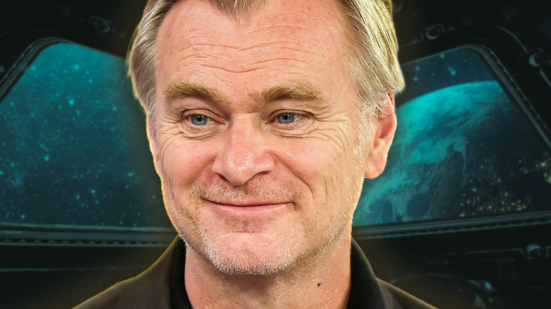 Christopher Nolan smiling against a background image of outer space