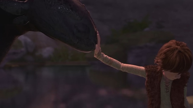 Toothless nudging his head against Hiccup's hand in How to Train Your Dragon