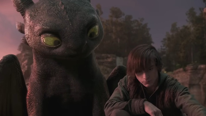 Toothless looking at Hiccup drawing in the sand in How to Train Your Dragon