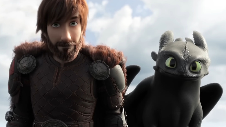 An older Hiccup standing next to Toothless in How to Train Your Dragon: The Hidden World