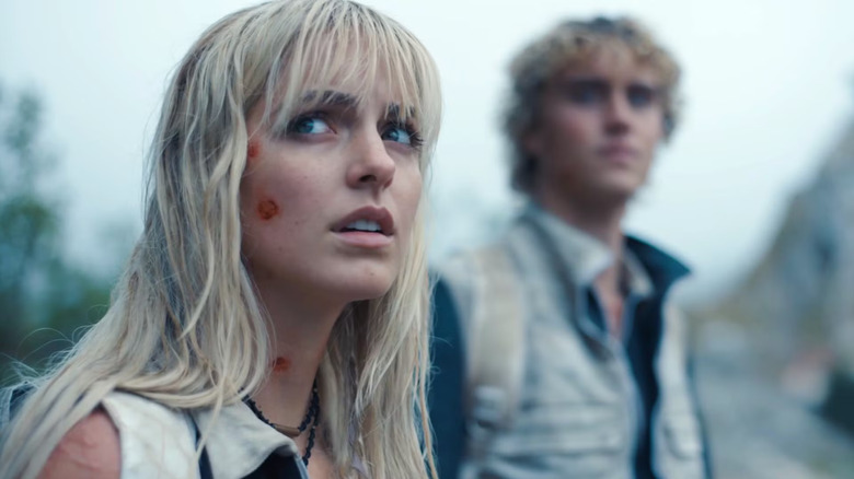 Maysilee with injuries on her face with Haymitch behind her in