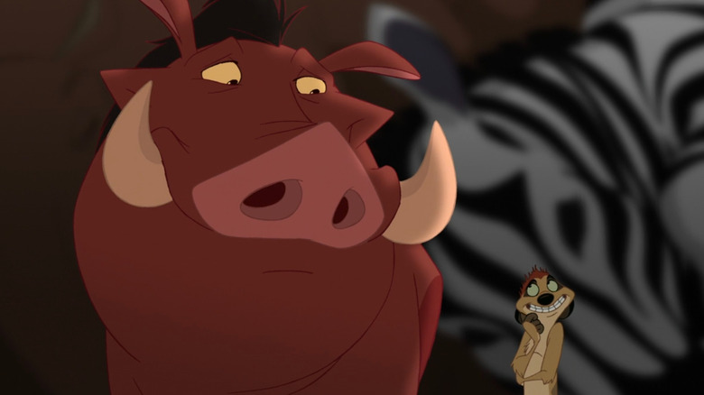 Timon and Pumbaa standing next to a herd of animals in The Lion King 1½