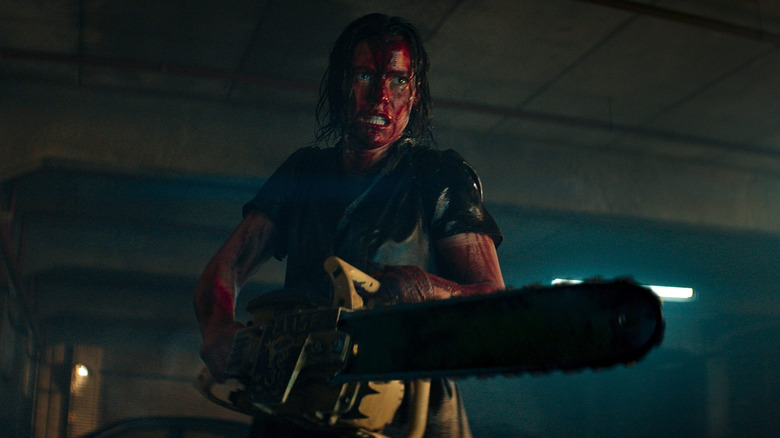 Beth on the offensive with a chainsaw in Evil Dead Rise (2023)