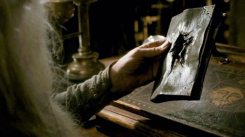 Dumbledore holding Tom Riddle's diary with