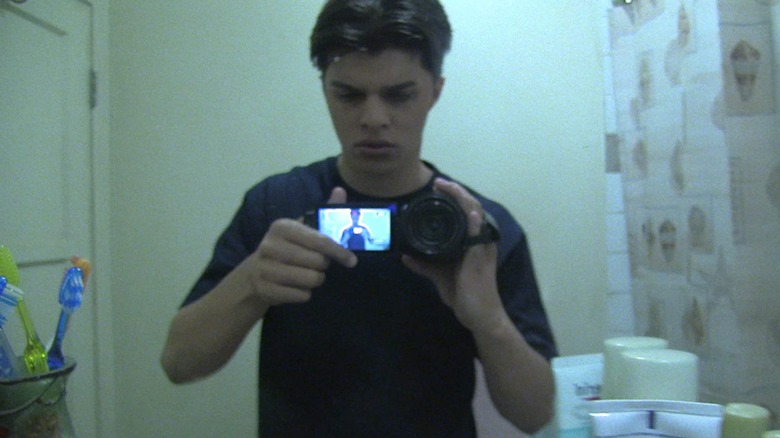 Young man films himself in the mirror