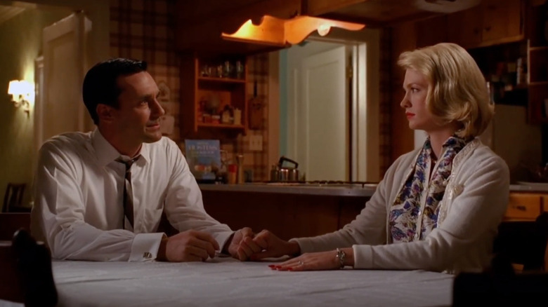 Don and Betty holding hands at their kitchen table on "Mad Men"