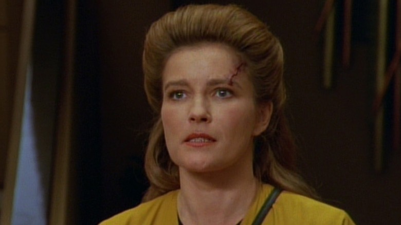 Captain Janeway with a facial scar and a serious expression in Star Trek: Voyager