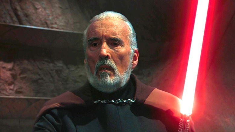 Count Dooku scowling with his red lightsaber ignited while facing Obi-Wan and Anakin in Attack of the Clones (2002)