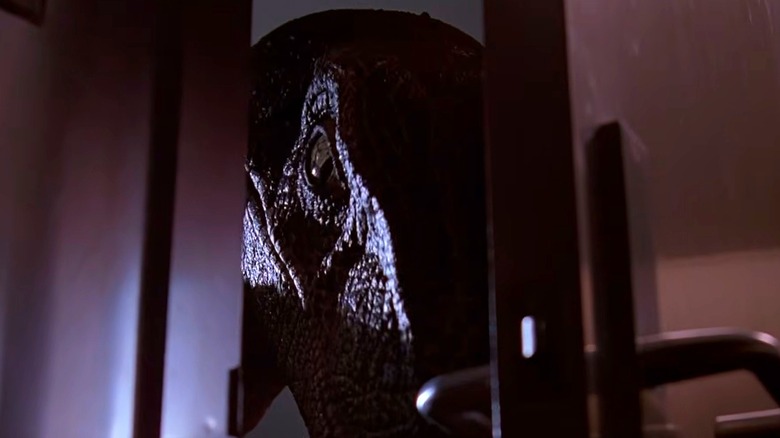 A velociraptor nudging against a door in Jurassic Park