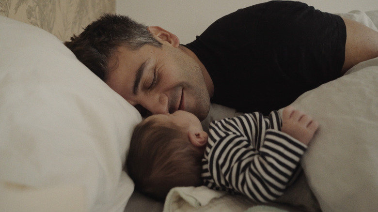Oscar Isaac lies next to his baby in "King Hamlet" (2025)