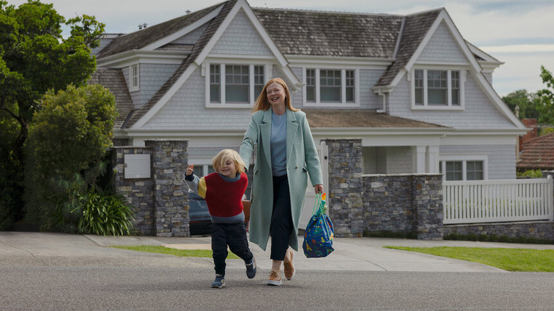 Milo smiling and running ahead of Marissa outside of their house on All Her Fault