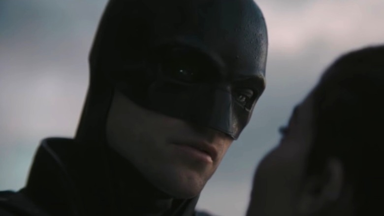Batman investigating someone's face