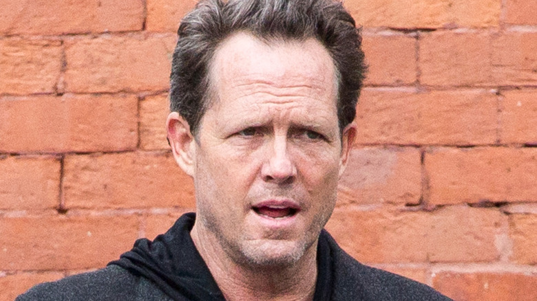 Dean Winters in front of a brick wall