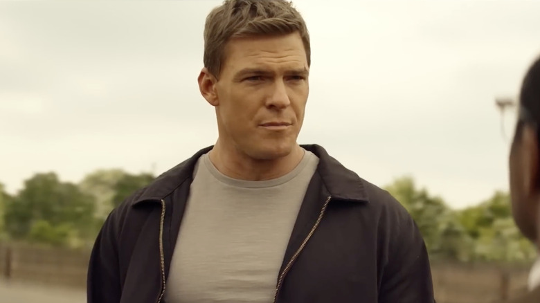 Jack Reacher wearing black jacket over grey shirt