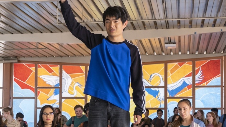 Jin Wang raising arm in front of students