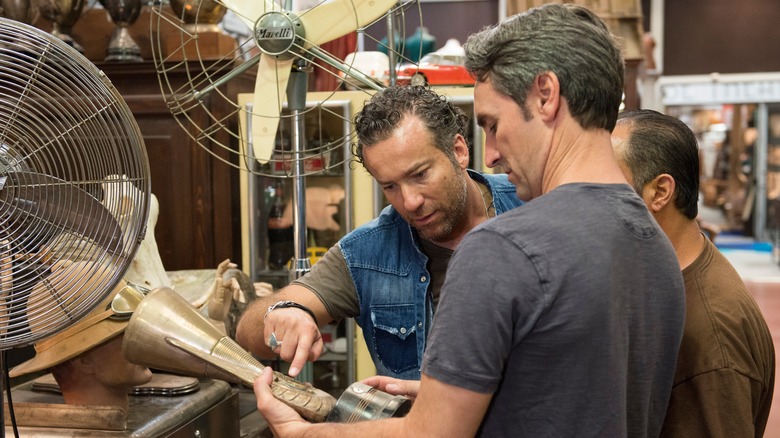 Mike and Frank examine an item