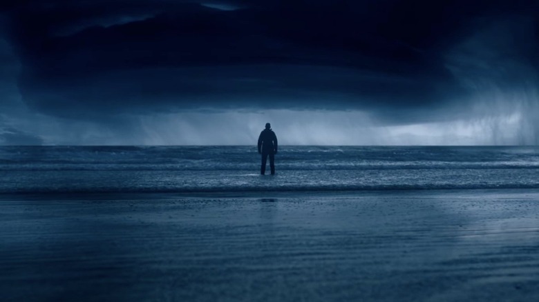 Ray faces a storm standing in the ocean in 