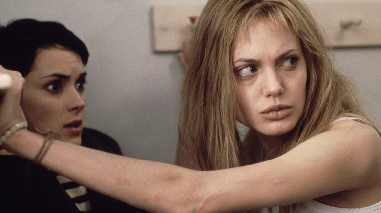 Angry Angelina Jolie holds arm across scared Winona Ryder