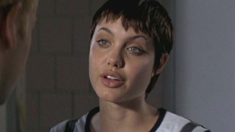 Short-haired Angelina Jolie cocks head talks to man